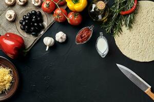 Pizza cooking ingredients. Dough, vegetables and spices. Top view with copy space photo