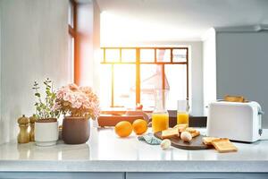 Portion of toasts on a wooden board with orange juice. Breakfast is served on a table with light blue napkin. photo