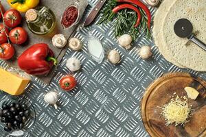 Cheese, different vegetables on metal table. Ingredients for traditional italian pizza. photo