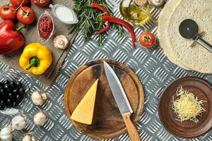 Cheese, different vegetables on metal table. Ingredients for traditional italian pizza. photo