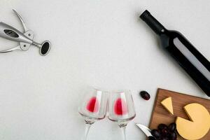 Wine, glasses and corkscrew over white background. Top view photo