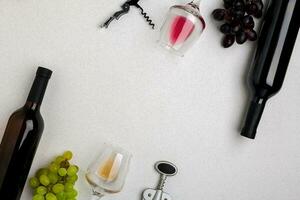 Glasses and bottles of red and white wine on white background from top view photo