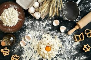 Woman smashes an egg using knife while kneading a pastry. Studio shot. Top view photo