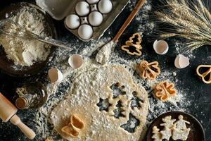 Dough for ginger biscuits rolled up on a table and cut using molds photo