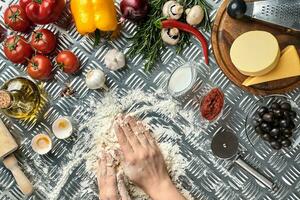 Pizza dough with ingredients on iron background, shot from above. photo