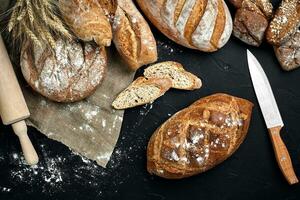 Mixed breads on black table. Top view with copy space. photo