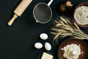 Pasta cooking ingredients on black kitchen table. Top view with space for your text photo