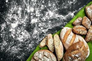 Mixed breads on black table. Top view with copy space. photo