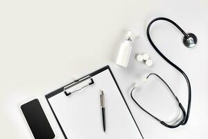 Stethoscope, pills, tablet on white background. Medicine concept photo