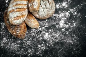 Mixed breads on black table. Top view with copy space. photo