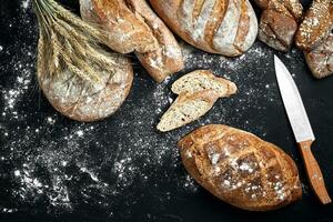Mixed breads on black table. Top view with copy space. photo