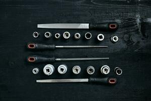 Set of tools chisel, wrenches on black wooden background photo