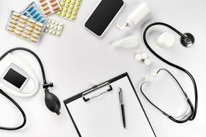 Stethoscope in the office of doctors.Top view of doctor's desk table, blank paper on clipboard with pen. Copy space. Designer's blank photo