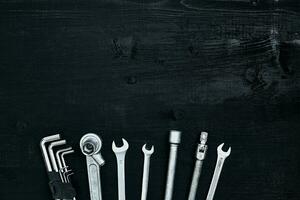 Tools for work or repair auto on black wooden background. Top view photo