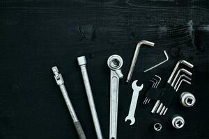 Tools for work or repair auto on black wooden background. Top view photo