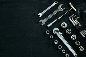 Set of hand bunch of tools in the garage on black wooden background photo