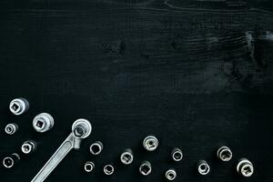 Tools for car repair in Workshop. Car repair equipment on black wooden background in car repair shop photo