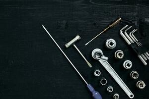 Set of hand bunch of tools in the garage on black wooden background photo