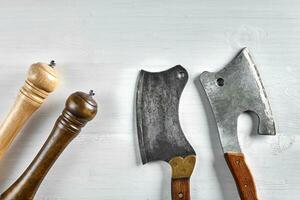 Kitchen ax, knife, cleaver, cutter with wooden handle. Axe on light background with spices. Ax for meat. Vintage photo