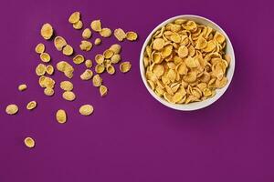 Bowl with cornflakes on the colorful background photo