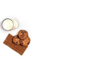 Glass of milk and cookies on white background with space for text or design. Top view photo