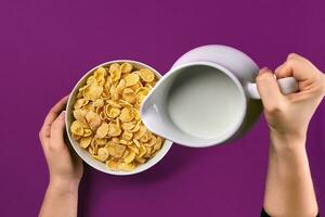 comida y personas concepto manos de mujer comiendo cereales maíz copos para desayuno y torrencial Leche foto