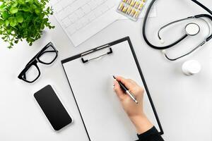 Doctor's work with stethoscope and copybook on hospital desk background. Top view photo