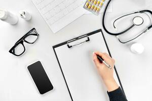 Doctor's work with stethoscope and copybook on hospital desk background. Top view photo