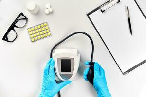 White electric tonometer on white table for measuring blood pressure with stethoscope. Measurement of pressure and pulse. photo