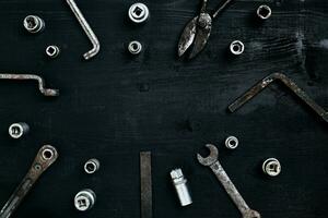 Old, rusty tools lying on a wooden table. Hammer, chisel, metal scissors, wrench, chisel. photo