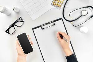 Doctor's work with stethoscope and copybook on hospital desk background. Top view photo