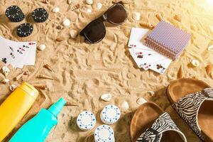 poker de playa. papas fritas y tarjetas en el arena. alrededor el conchas marinas, Gafas de sol y dar la vuelta fracasos parte superior ver foto