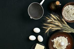 Pasta cooking ingredients on black kitchen table. Top view with space for your text photo