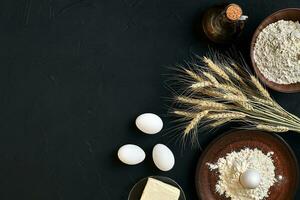 Pasta cooking ingredients on black kitchen table. Top view with space for your text photo