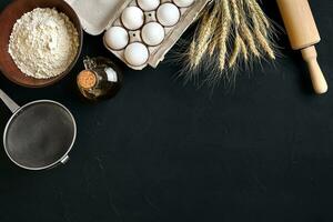 Pasta cooking ingredients on black kitchen table. Top view with space for your text photo