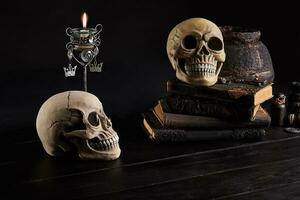 Realistic model of a human skull with teeth on a wooden dark table, black background. Medical science or Halloween horror concept. Close-up shot. photo