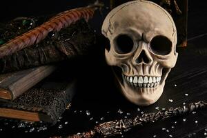 Realistic model of a human skull with teeth on a wooden dark table, black background. Medical science or Halloween horror concept. Close-up shot. photo