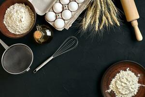 Pasta cooking ingredients on black kitchen table. Top view with space for your text photo