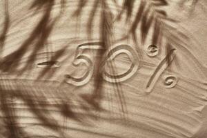 Summer concept with a shadow of a tropical palm tree leaves, copyspace on a white beach sand. photo