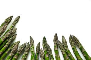 An edible, raw stems of asparagus isolated on white background. photo