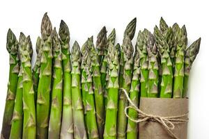 An edible, raw stems of asparagus isolated on white background. photo