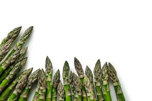 An edible, raw stems of asparagus isolated on white background. photo