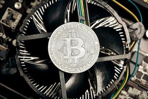 Bitcoin. New virtual money. Bitcoins lie on the video card, concept of mining. photo