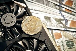 The coin of bitcoin lies on video card with dollars. Exchange bitcoin cash for a dollar photo