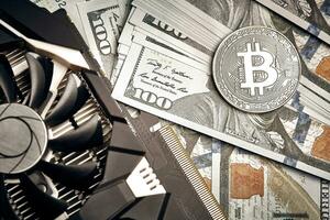 The coin of bitcoin lies on dollars with video card. Exchange bitcoin cash for a dollar photo