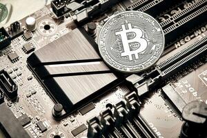 Bitcoin. New virtual money. Bitcoins lie on the video card, concept of mining. photo