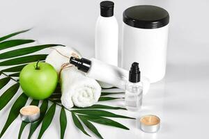 Natural spa beauty treatment cleansing products with apple on white background. photo