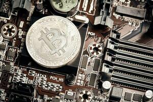 Bitcoin. New virtual money. Bitcoins lie on the video card, concept of mining. photo