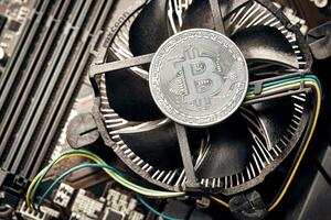 Bitcoin. New virtual money. Bitcoins lie on the video card, concept of mining. photo