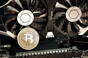 Bitcoin. New virtual money. Bitcoins lie on the video card, concept of mining. photo